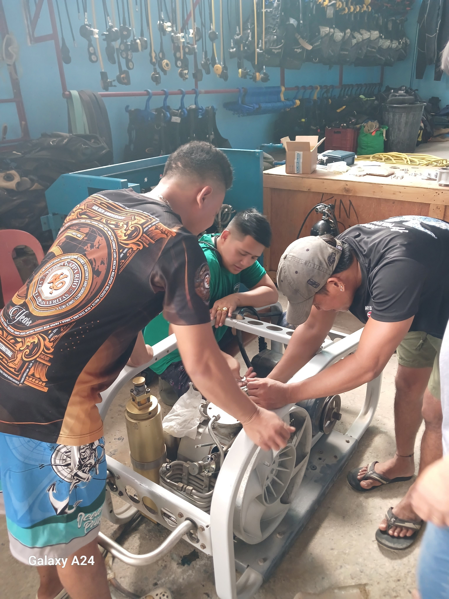 Technicians servicing a portable compressor inside the shop